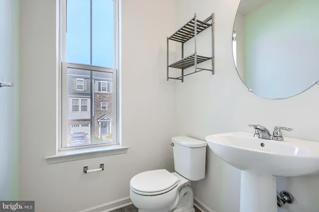 a bathroom with a toilet a sink and mirror