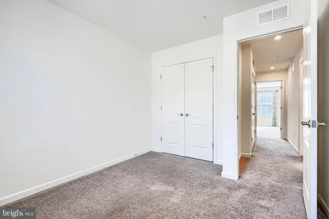 an empty room with a bathroom and mirror