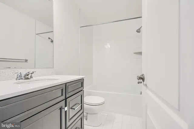 a bathroom with a granite countertop sink toilet a shower and a mirror