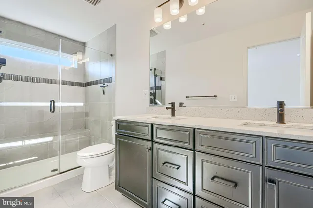 a bathroom with a double vanity sink mirror and toilet
