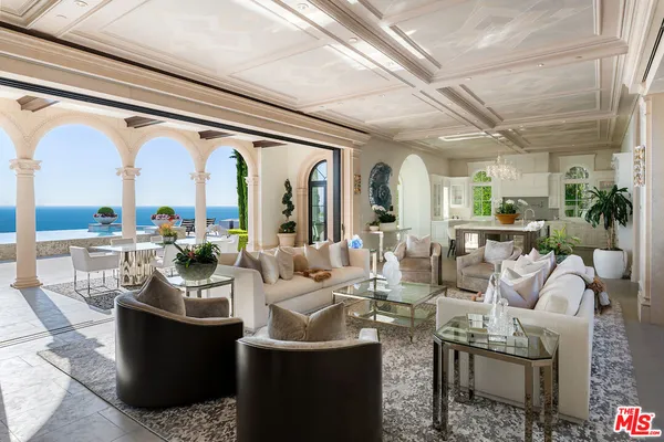 a very nice looking living room with a large window and chandelier