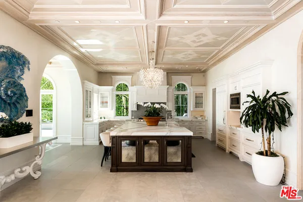 a living room with a chandelier furniture and a potted plant