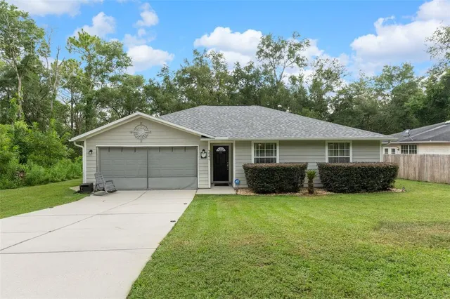 a front view of a house with yard and garage