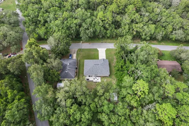 an aerial view of a house with a yard and lake view
