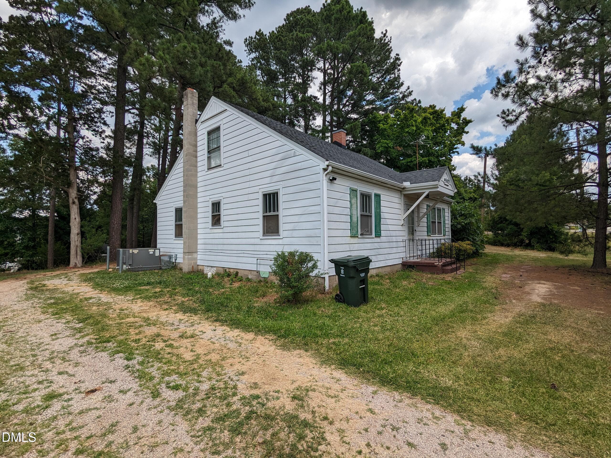 4503 Hopson Road Morrisville, NC 27560 - Photo 3 of 5 a backyard of a house with potted plants and large trees