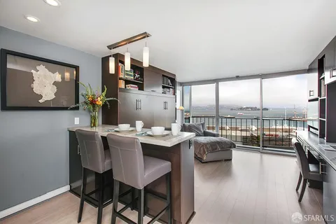 a kitchen with granite countertop a sink cabinets and wooden floor