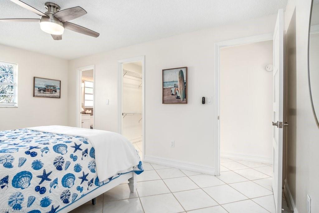 1207 Hernando Street Naples, FL 34103 - Photo 17 of 37 a bedroom with a bed and a chandelier