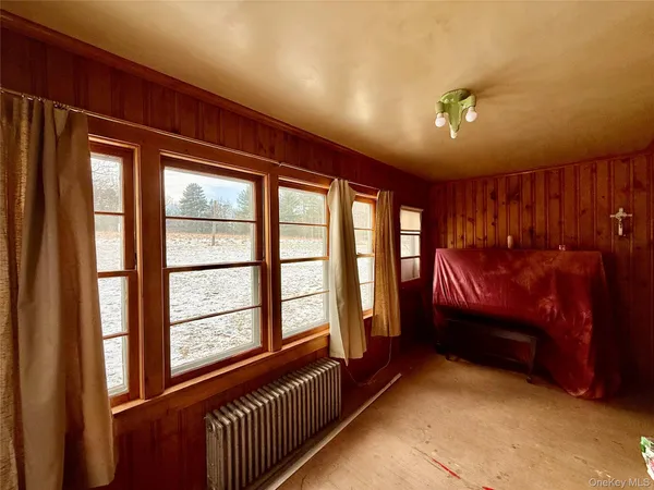 a view of a hallway with a livingroom and a window