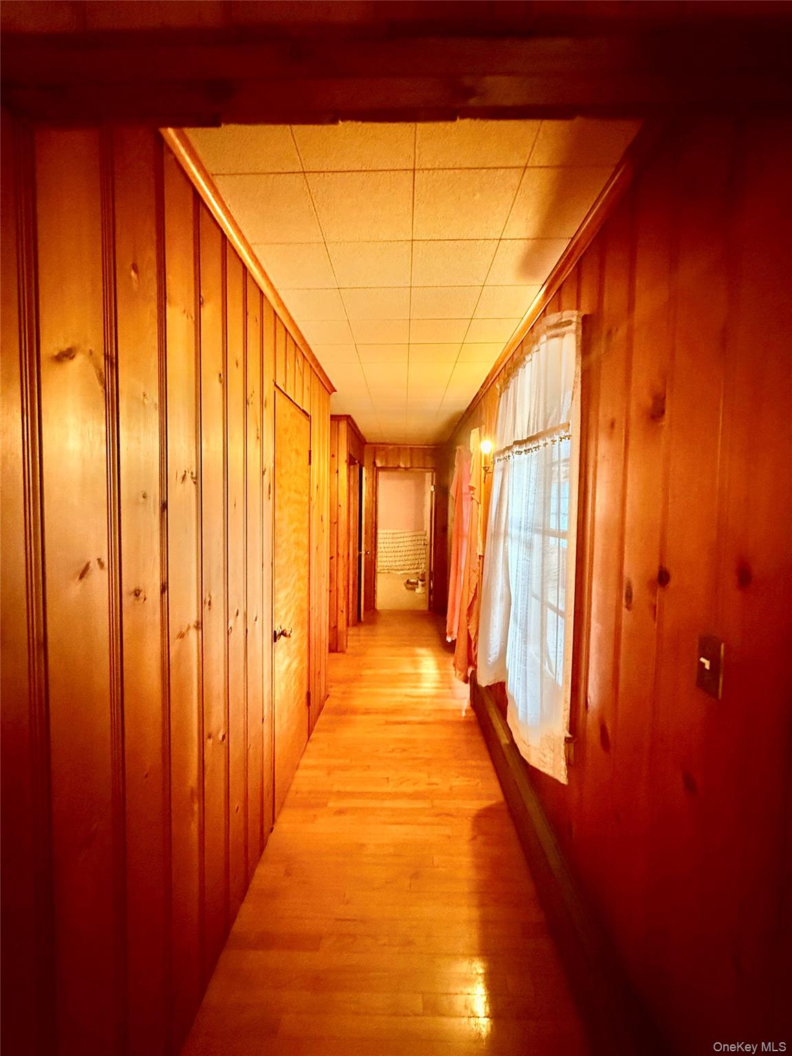 111 Mail Road Barryville, NY 12719 - Photo 22 of 34 Hall with wood walls, a drop ceiling, and light wood-type flooring