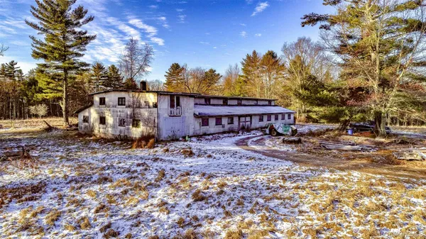 a view of a house with a yard tree and wooden fence