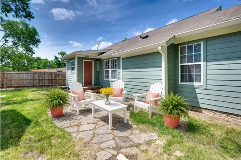 a view of a chair and table in backyard of the house
