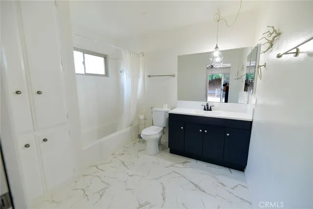 a spacious bathroom with a double vanity sink toilet and shower