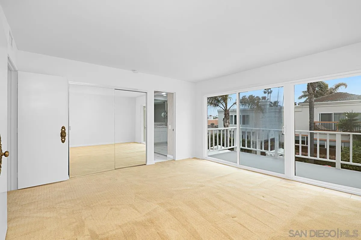 69 Half Moon Bend Coronado, CA 92118 - Photo 27 of 45 a spacious bedroom with a balcony a bed and a large window