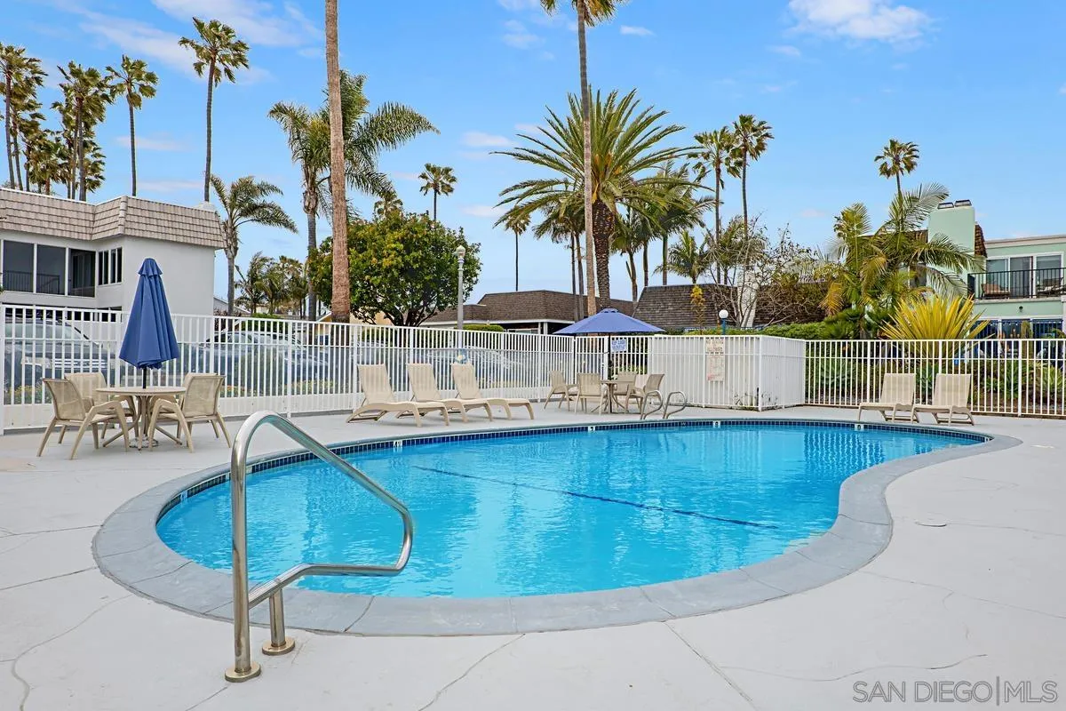 69 Half Moon Bend Coronado, CA 92118 - Photo 39 of 45 a view of a swimming pool with a lawn chairs and palm tree