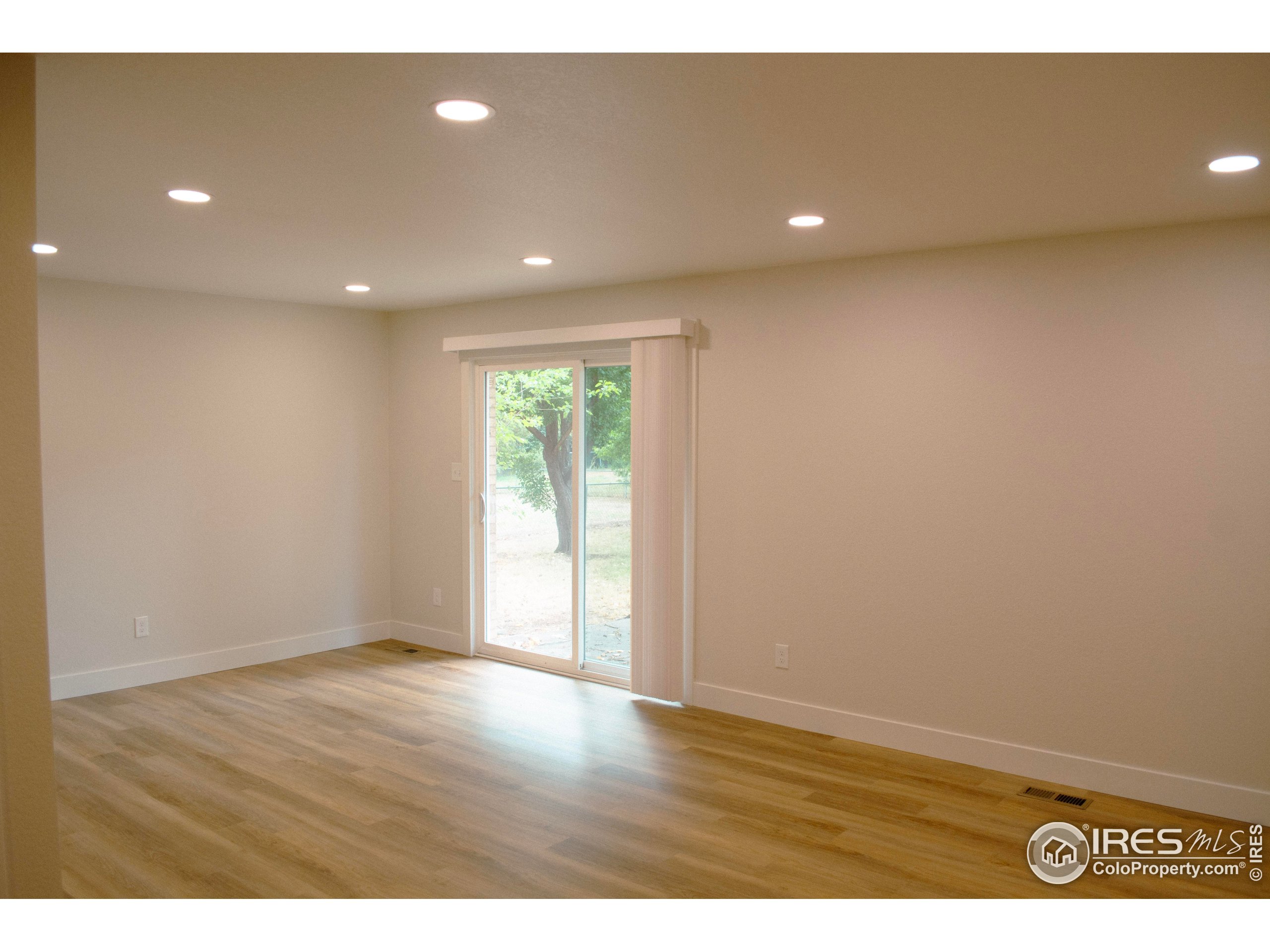 805 Gallup Road Fort Collins, CO 80521 - Photo 7 of 14 a view of an empty room with wooden floor and a window