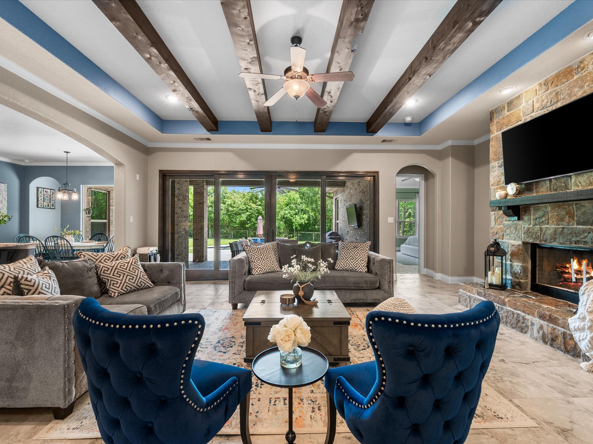 12618 Ranger Court Magnolia, TX 77354 - Photo 10 of 45 The open-concept layout features wood-beamed ceilings, a stunning stone fireplace, and large sliding doors that fill the home with natural light