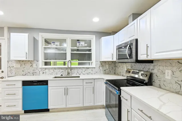 a kitchen with stainless steel appliances granite countertop a sink stove and microwave