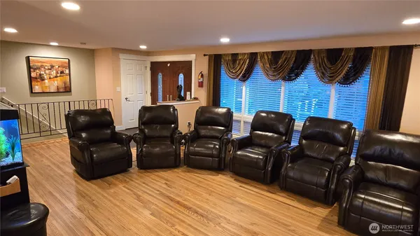 a media room with lots of chairs and wooden floor