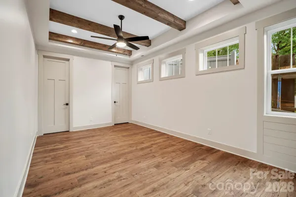 a view of empty room with wooden floor