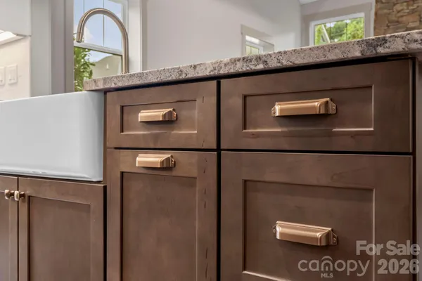 a bathroom with a granite countertop sink and a window