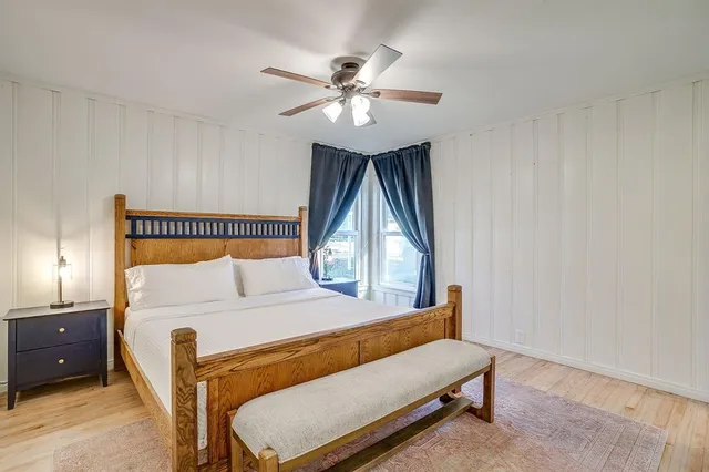 a bedroom with a bed window and a chandelier