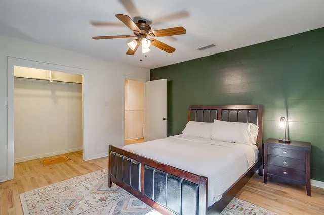 a bedroom with a large bed and a chandelier