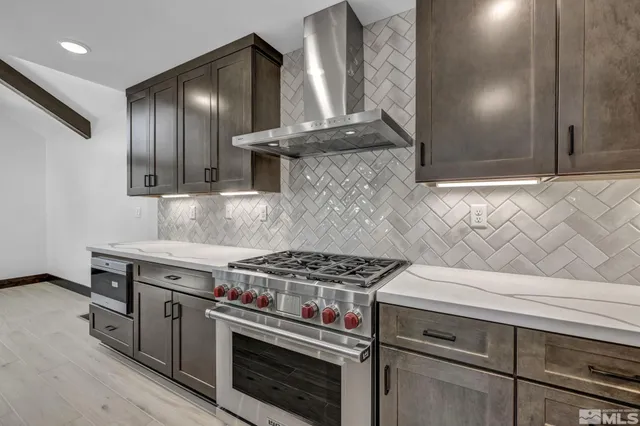 a kitchen with granite countertop a stove and a wooden floor