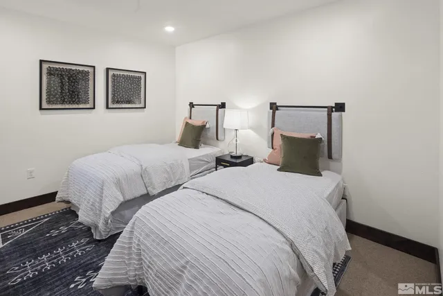 a bedroom with two beds and painting on the wall