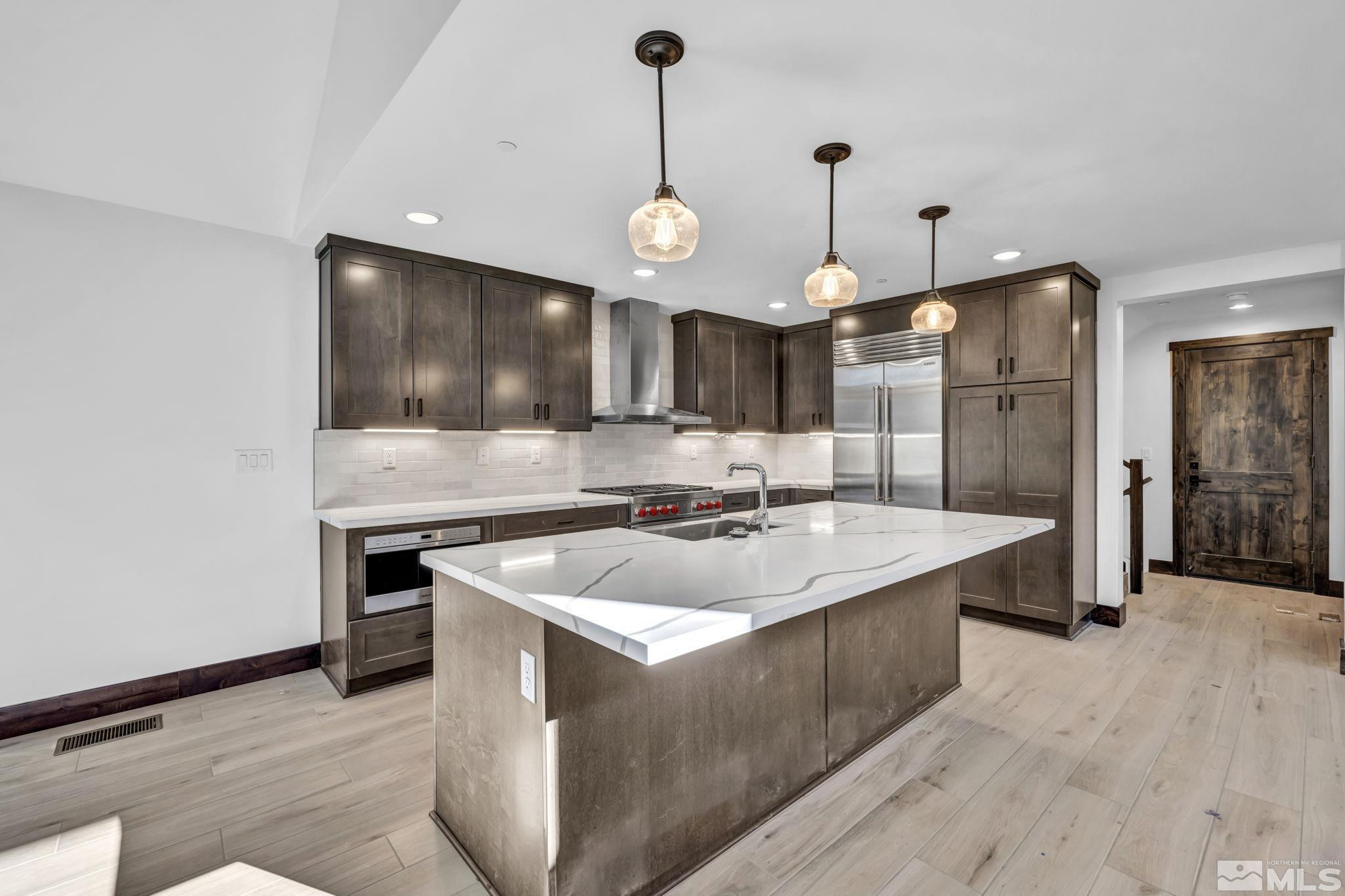 146 Sierra Colina Drive, Unit 34 Stateline, NV 89449 - Photo 9 of 38 a large kitchen with granite countertop a sink a stove and a wooden floors