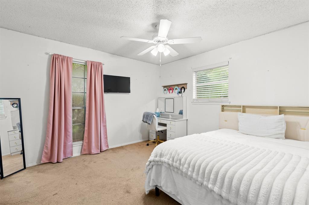 505 Pinewood Lane Hewitt, TX 76643 - Photo 21 of 38 Carpeted bedroom featuring a ceiling fan, two windows with blinds, and white painted walls