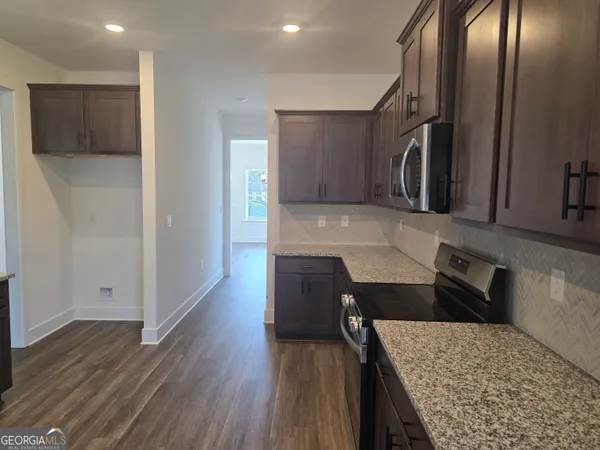 a kitchen with stainless steel appliances granite countertop a refrigerator a sink and wooden cabinets