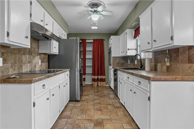 a kitchen with stainless steel appliances granite countertop a sink and cabinets