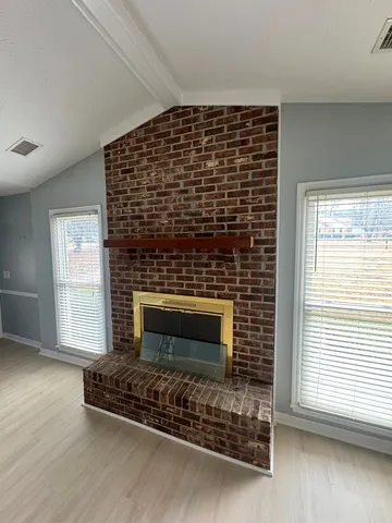 a living room with a fireplace in front of a window