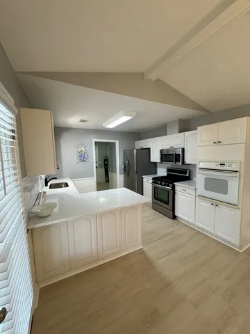 a view of an empty room with a fireplace and a window