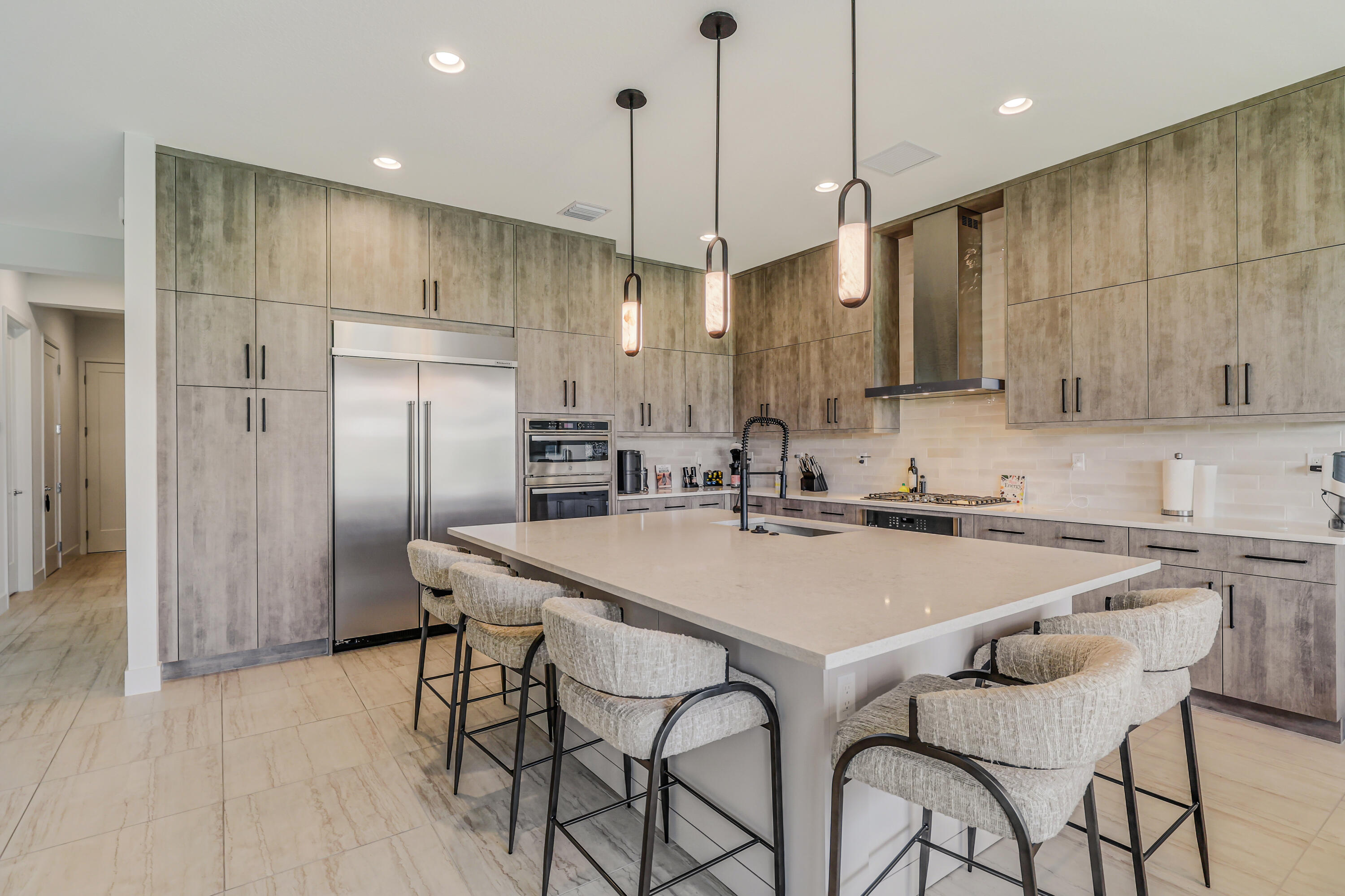 8283 Royal County Down Road Boca Raton, FL 33434 - Photo 13 of 88 a kitchen with stainless steel appliances granite countertop a table chairs wooden floors and a view of living room