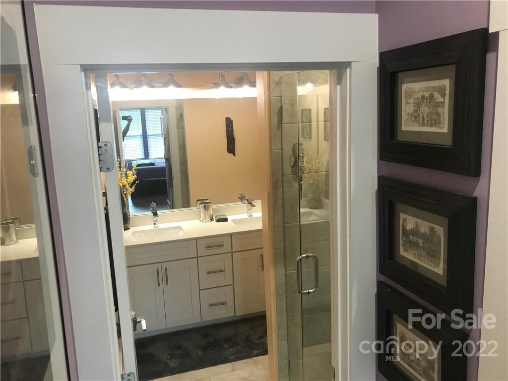 935 McAlway Road, Unit 306 Charlotte, NC 28211 - Photo 27 of 35 a bathroom with a double vanity sink toilet and shower