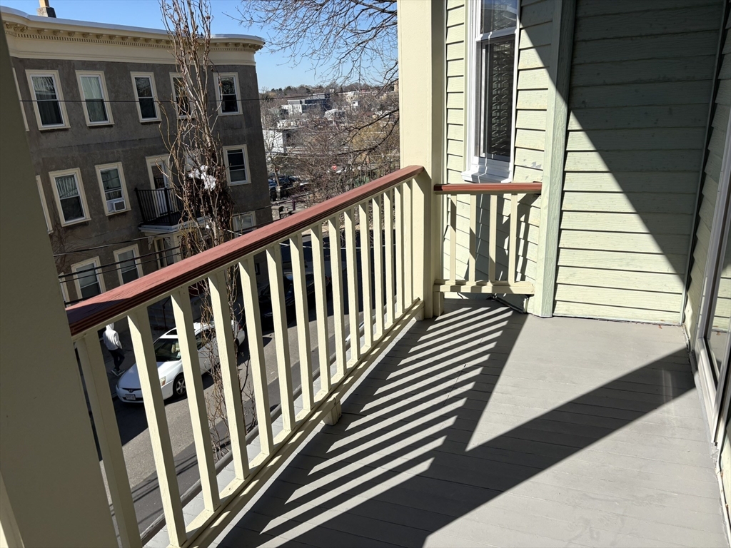 62 Ibbetson Street, Unit 3L Somerville, MA 02143 - Photo 4 of 20 a view of a balcony with wooden floor and stairs
