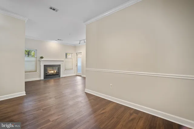 a view of a livingroom with wooden floor and a fireplace