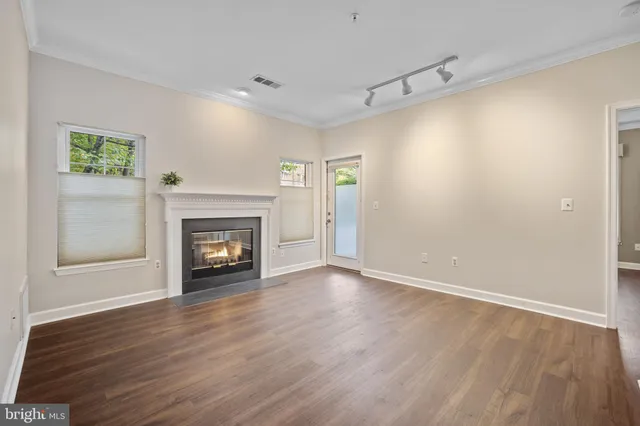 a view of an empty room with a fireplace and a window