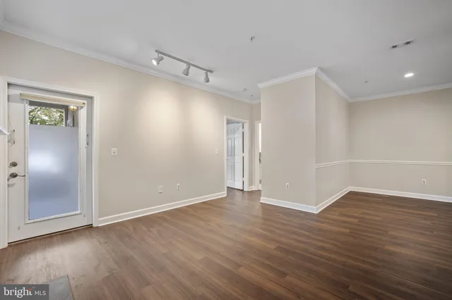 a view of an empty room with wooden floor