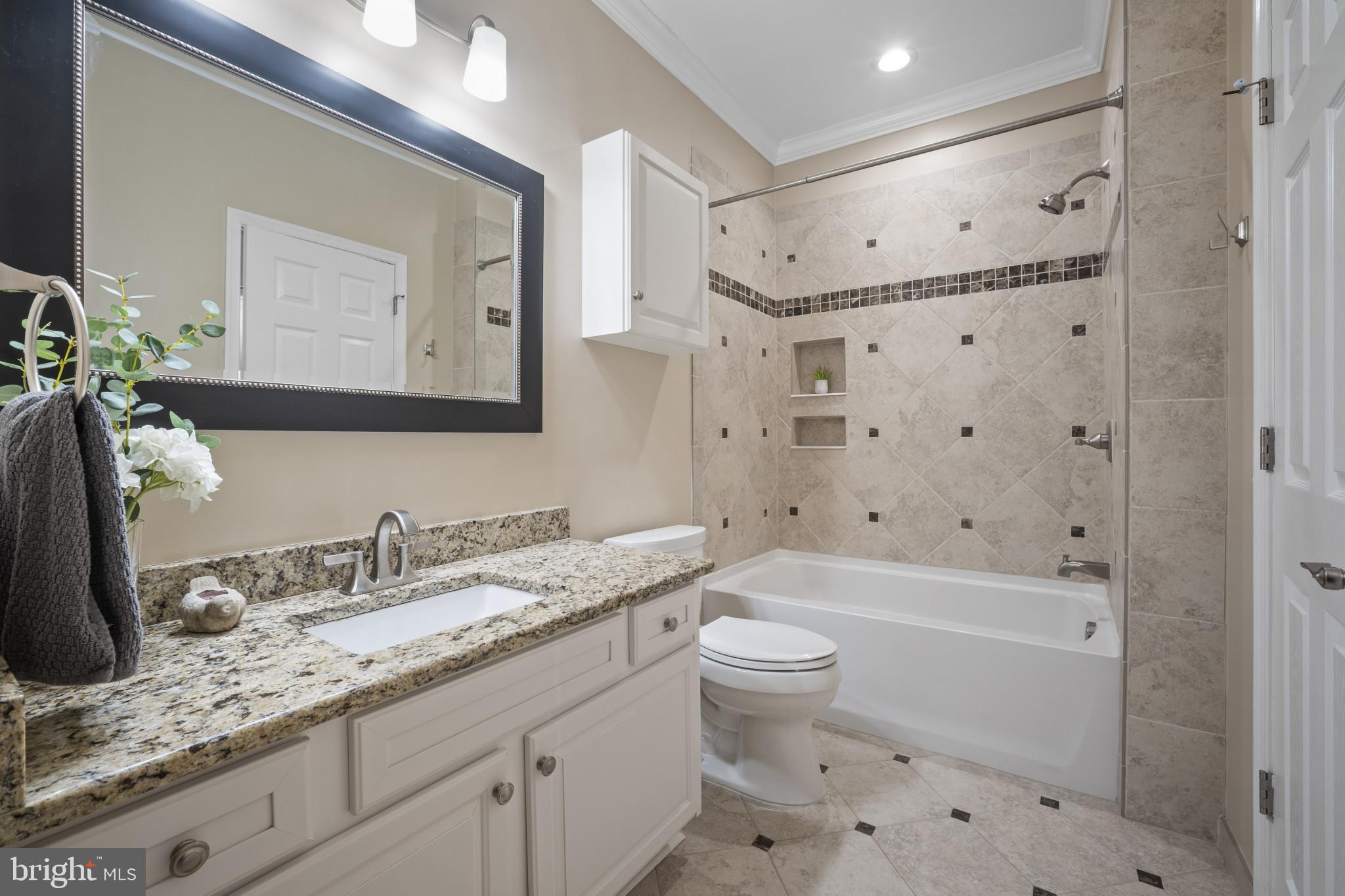 12005 Taliesin Place, Unit 16 Reston, VA 20190 - Photo 21 of 33 a bathroom with a granite countertop sink a toilet a mirror a shower and bathtub