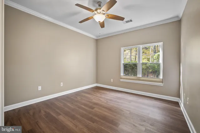 an empty room with a window and a ceiling fan