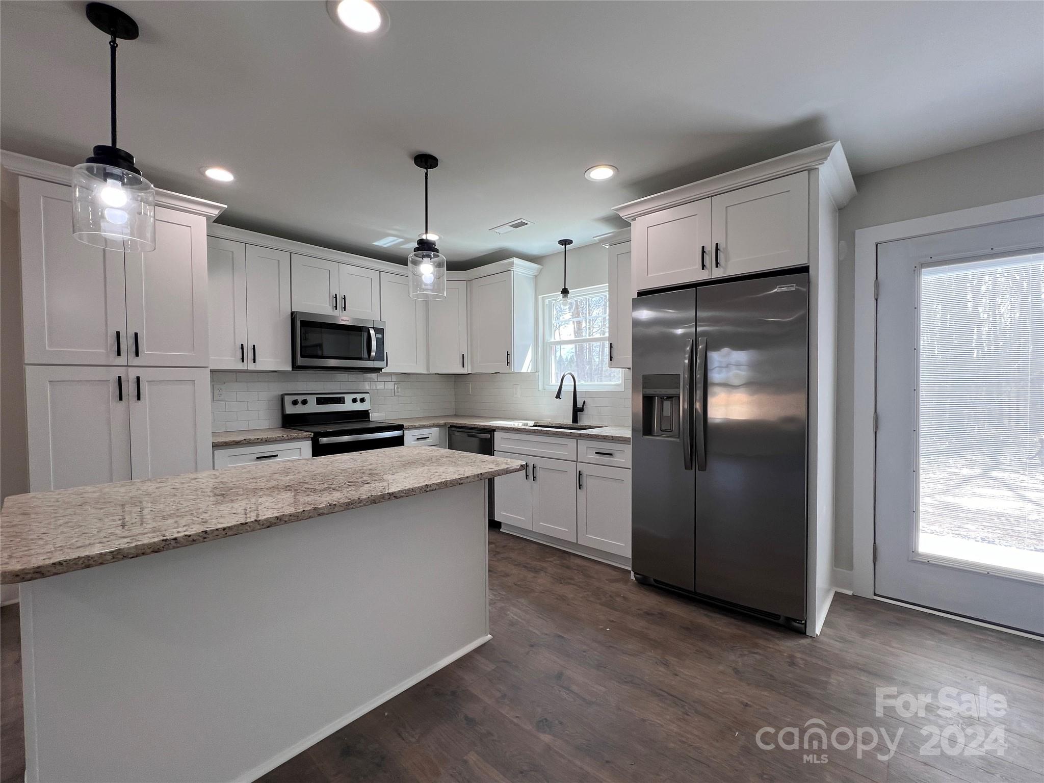 3610 Olive Branch Road Monroe, NC 28110 - Photo 2 of 15 a kitchen with kitchen island granite countertop appliances cabinets a sink and a center island