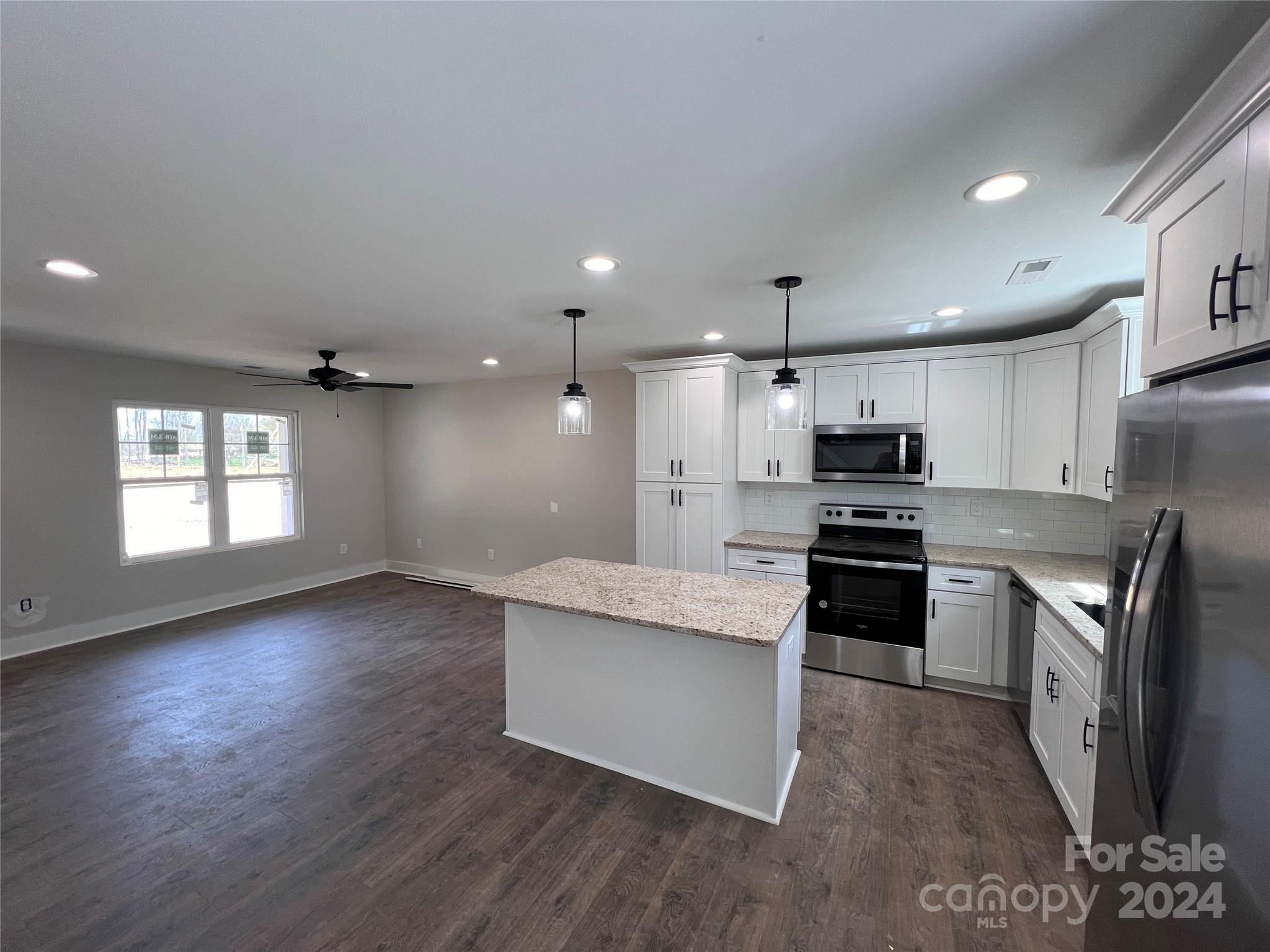 3610 Olive Branch Road Monroe, NC 28110 - Photo 3 of 15 a kitchen with stainless steel appliances kitchen island granite countertop a stove a sink and a refrigerator