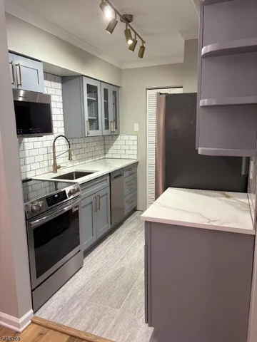 a kitchen with stainless steel appliances a sink stove and refrigerator
