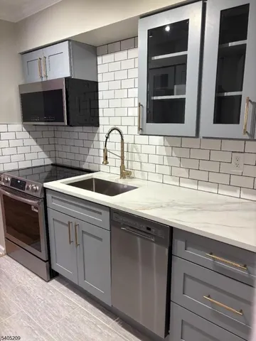a kitchen with stainless steel appliances granite countertop a sink and a microwave