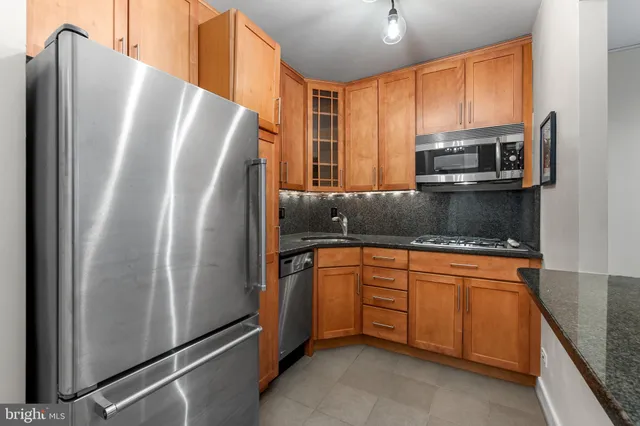 a kitchen with granite countertop a refrigerator and a sink