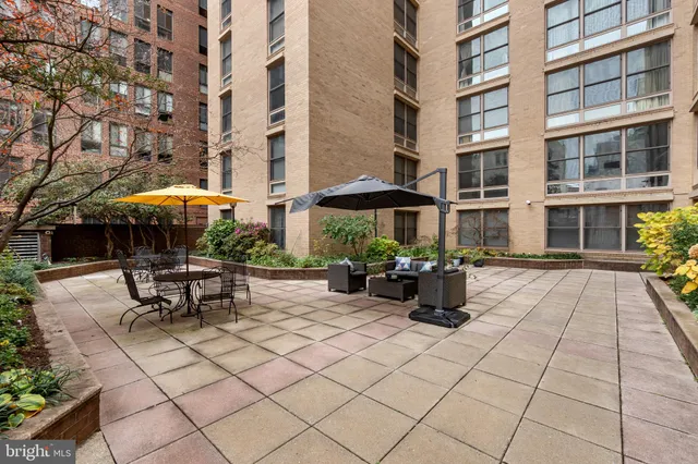 a view of patio with chairs and tables with a umbrella