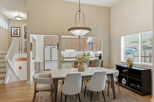 3674 Oak Rim Way Salt Lake City, UT 84109 - Photo 9 of 47 Dining space with vaulted ceilings, featuring an overhead chandelier, hardwood-finish flooring, and a pass-through opening to the kitchen