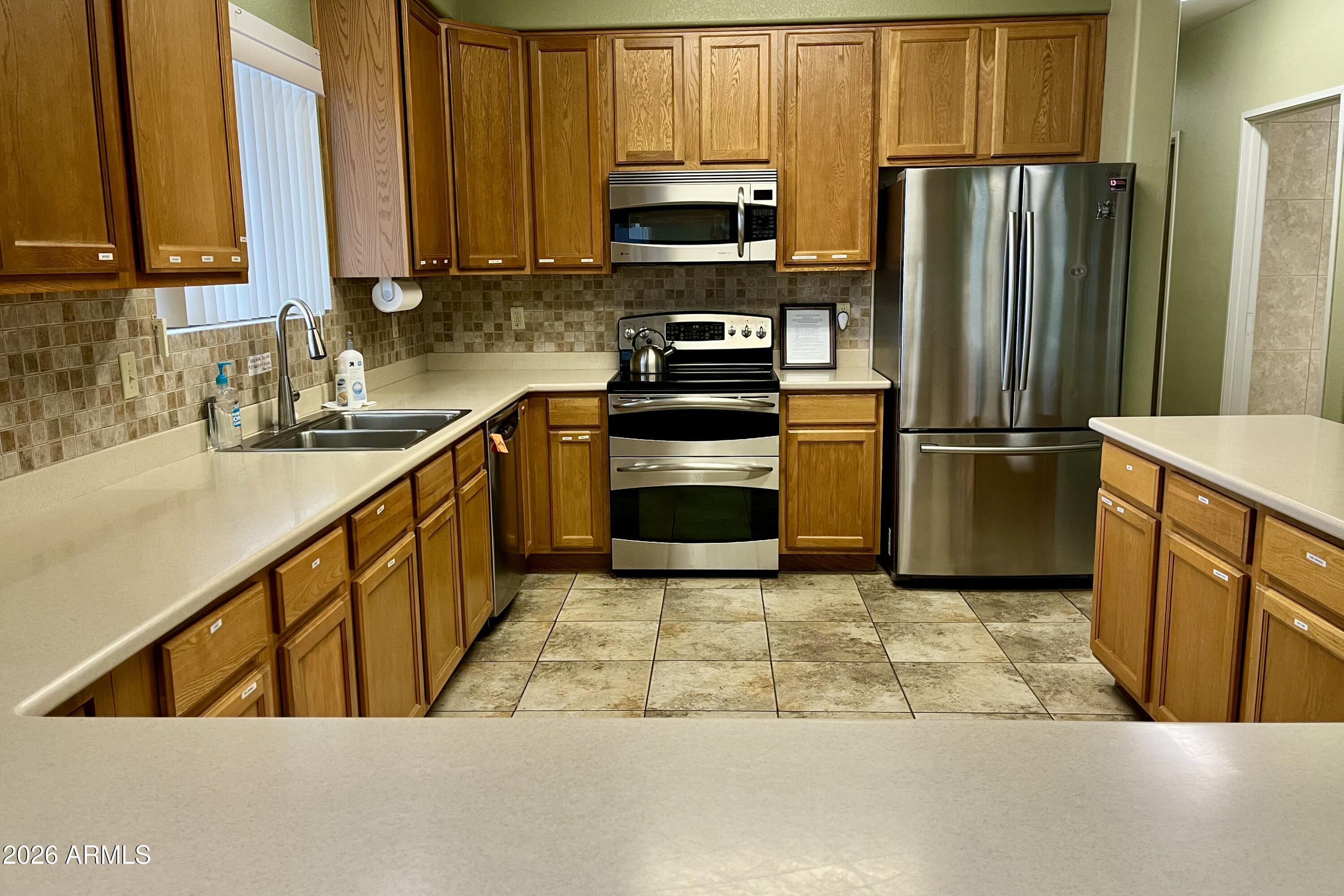 747 East Germann Road, Unit 92 San Tan Valley, AZ 85140 - Photo 36 of 39 a kitchen with stainless steel appliances granite countertop a refrigerator a stove a sink and a microwave
